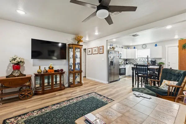 a kitchen with stainless steel appliances granite countertop a stove top oven a sink a stove a dining table and chairs
