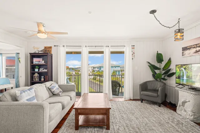 a living room with furniture wooden floor and a potted plant