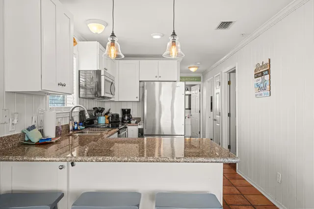 a kitchen with cabinets stainless steel appliances and sink