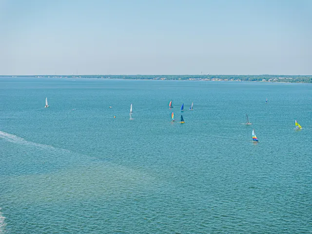 a front view of a house with a garden and lake view