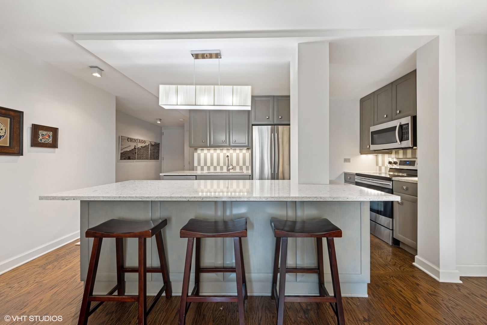 21 West Goethe Street, Unit 8DE Chicago, IL 60610 - Photo 6 of 22 a kitchen with kitchen island a dining table chairs cabinets and wooden floor