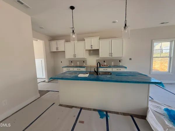 a kitchen with kitchen island a stove a sink a center island and cabinets
