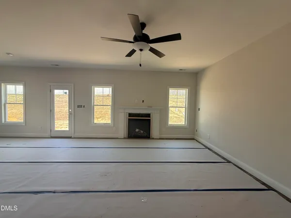 a view of an empty room with a fireplace and a window