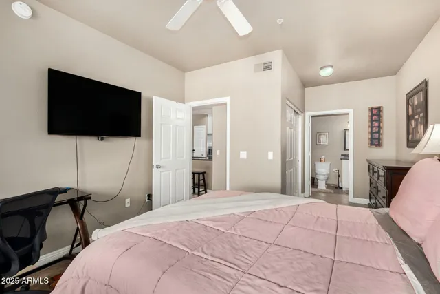 a bedroom with a bed window and a flat screen tv