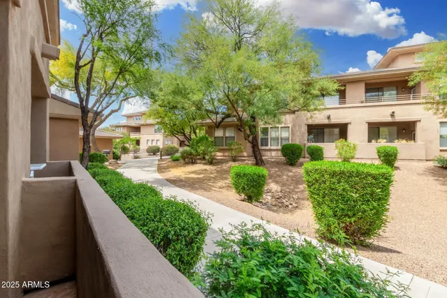 a front view of a house with a yard and fountain in middle