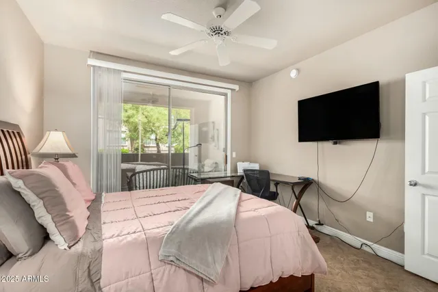 a bedroom with a bed tv and a window