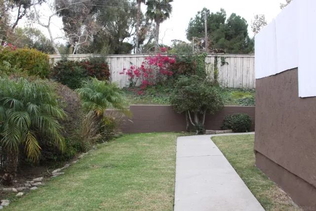 a view of flower garden with wooden fence