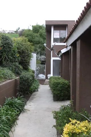 a house with a lot of plants in front of it