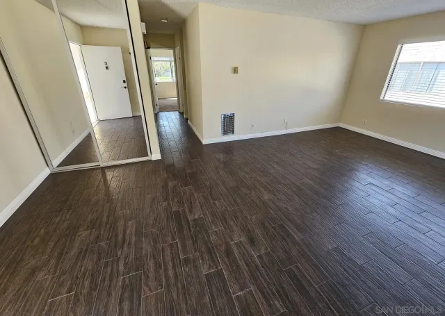 an empty room with wooden floor and a window