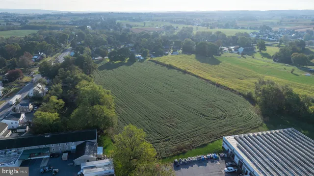 an aerial view of residential houses with outdoor space and trees