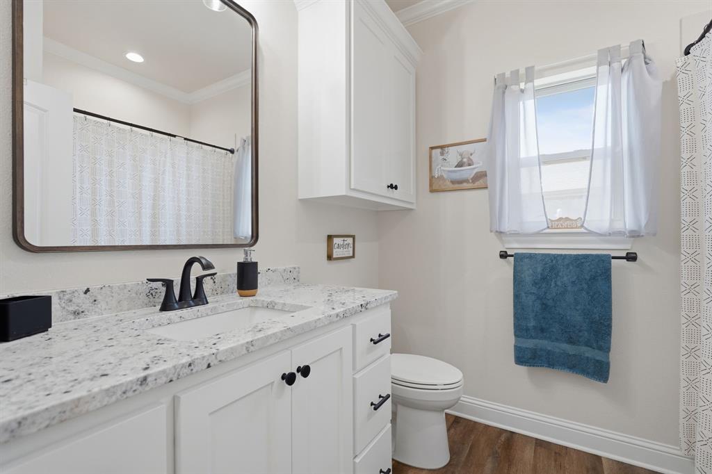 3302 Shelby Road Abilene, TX 79606 - Photo 22 of 29 a bathroom with a granite countertop sink a toilet and a mirror