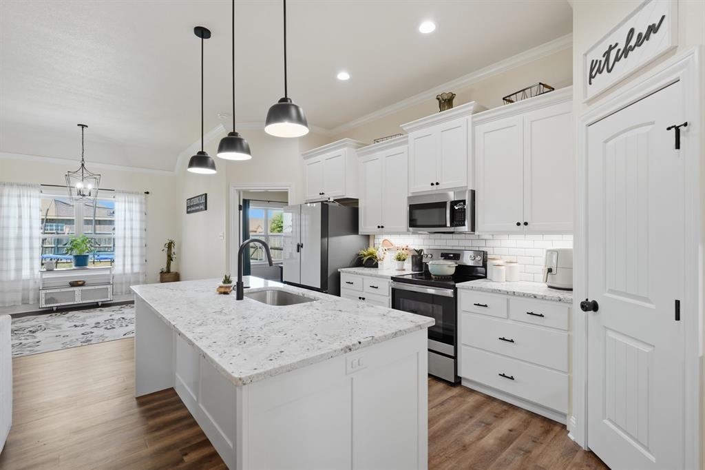 3302 Shelby Road Abilene, TX 79606 - Photo 6 of 29 a kitchen with stainless steel appliances kitchen island granite countertop a stove a sink and a refrigerator