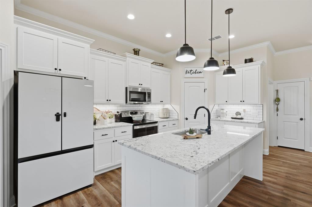3302 Shelby Road Abilene, TX 79606 - Photo 8 of 29 a kitchen with stainless steel appliances granite countertop a sink a stove a refrigerator and island with wooden floor