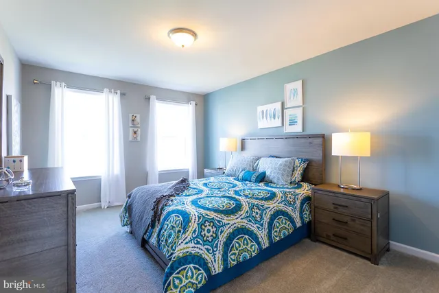 a bedroom with a bed and painting on the wall