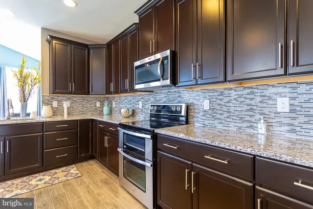 a kitchen with stainless steel appliances granite countertop a sink stove and microwave