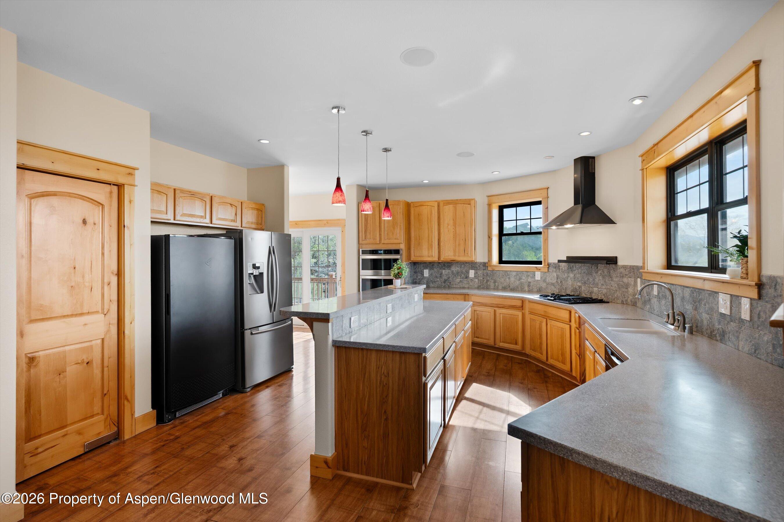 450 Summer Falls Road Silt, CO 81652 - Photo 9 of 50 a kitchen with stainless steel appliances granite countertop a refrigerator a stove and a sink with wooden floor