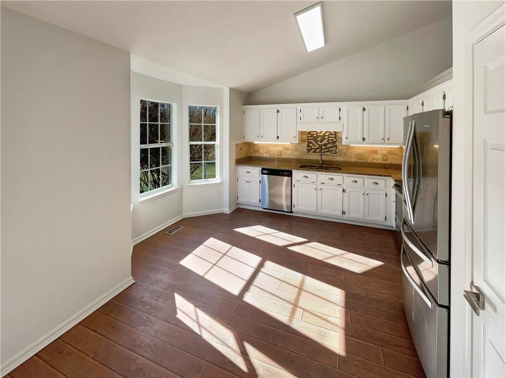 180 Honeysuckle Drive Southeast Calhoun, GA 30701 - Photo 7 of 21 a kitchen with stainless steel appliances granite countertop a stove a sink and a refrigerator