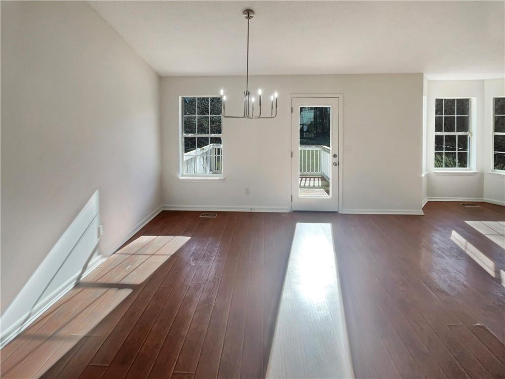 180 Honeysuckle Drive Southeast Calhoun, GA 30701 - Photo 8 of 21 a view of an empty room with wooden floor and a window