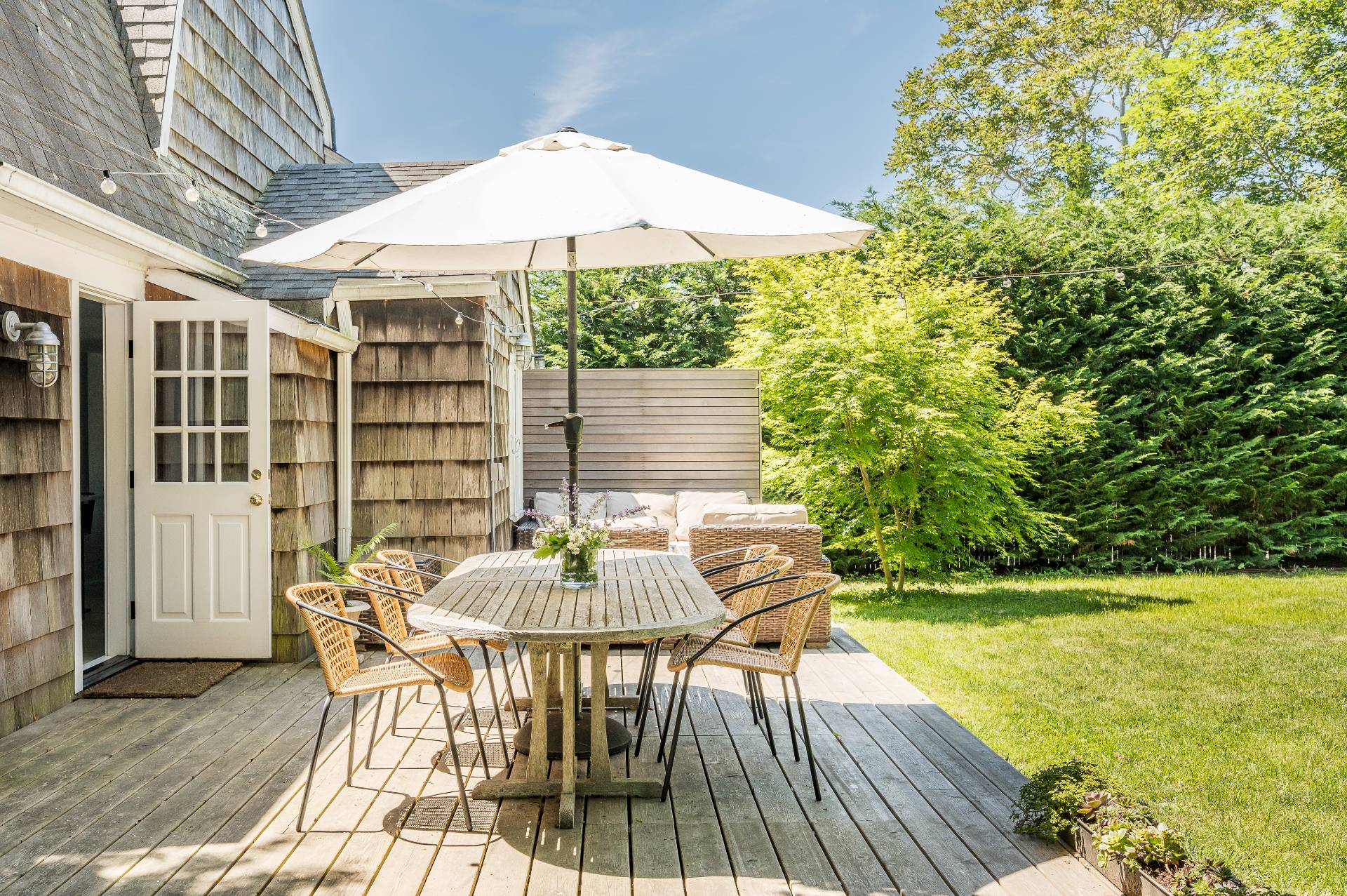 8 Collins Avenue East Hampton, NY 11937 - Photo 15 of 33 a patio with glass top table and chairs
