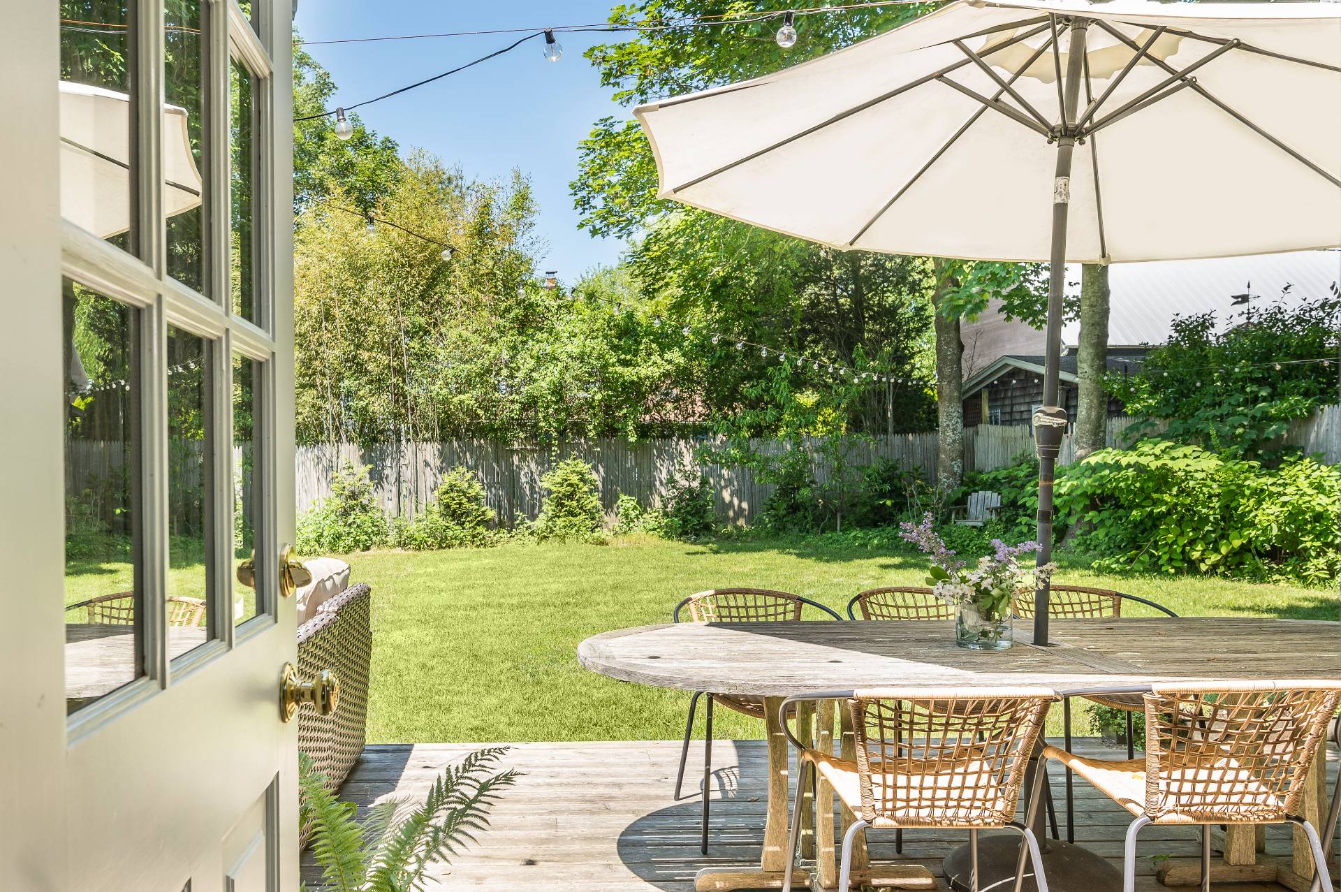 8 Collins Avenue East Hampton, NY 11937 - Photo 18 of 33 a view of a patio with table and chairs under an umbrella