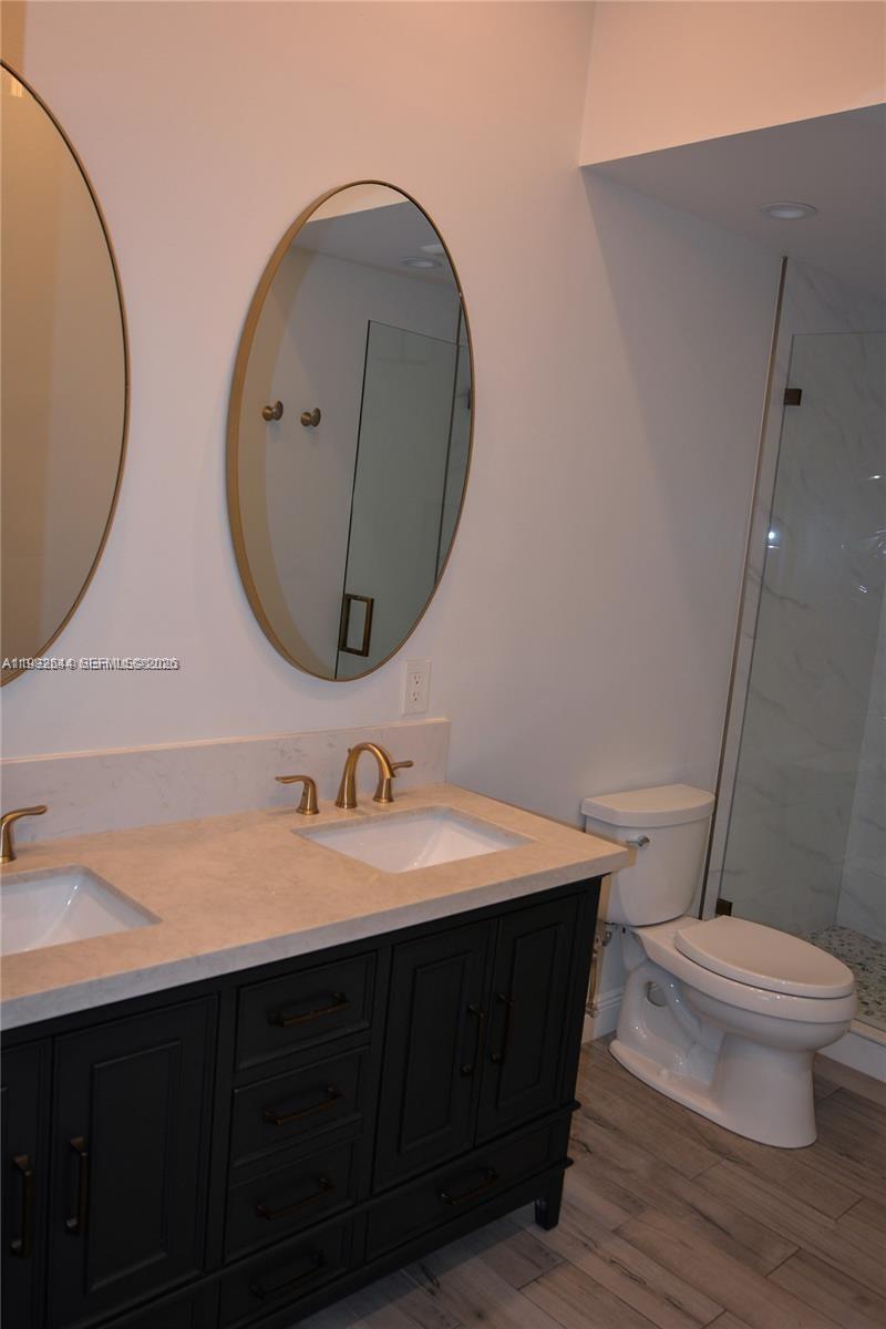 7849 Southwest 103rd Place Miami, FL 33173 - Photo 24 of 64 a bathroom with a double vanity sink mirror and toilet
