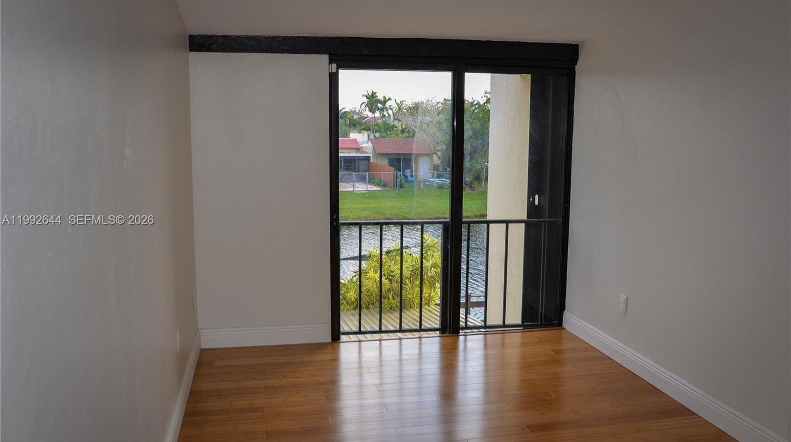 7849 Southwest 103rd Place Miami, FL 33173 - Photo 25 of 64 wooden floor in an empty room with a window