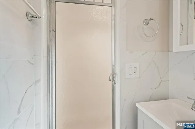 a bathroom with a granite countertop sink a toilet and shower