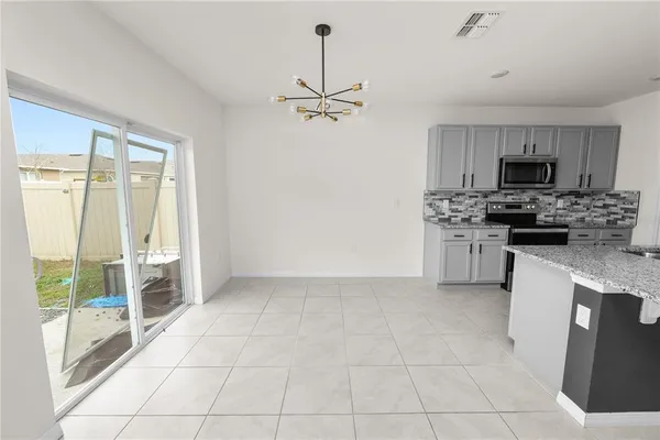 a view of kitchen with granite countertop cabinets and window