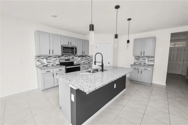 a kitchen with granite countertop a sink a stove and a wooden floor