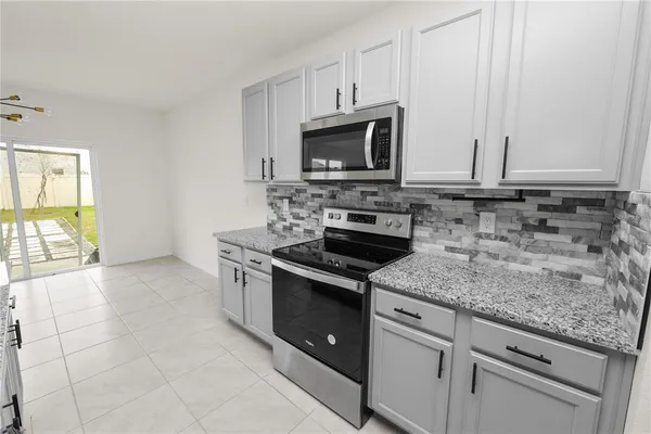 a kitchen with granite countertop a sink a counter top space and cabinets