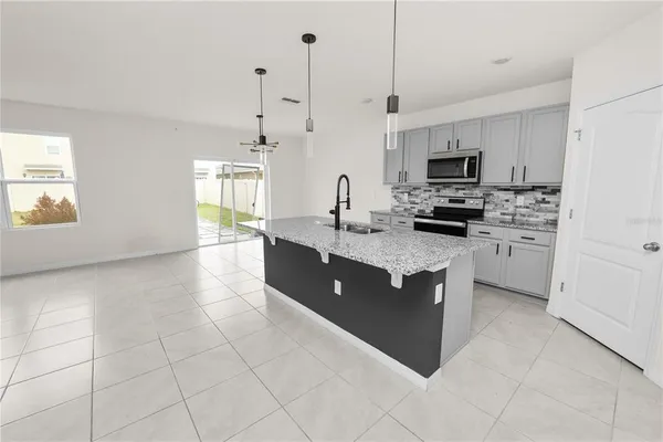 a kitchen with kitchen island a counter top space appliances and a cabinets