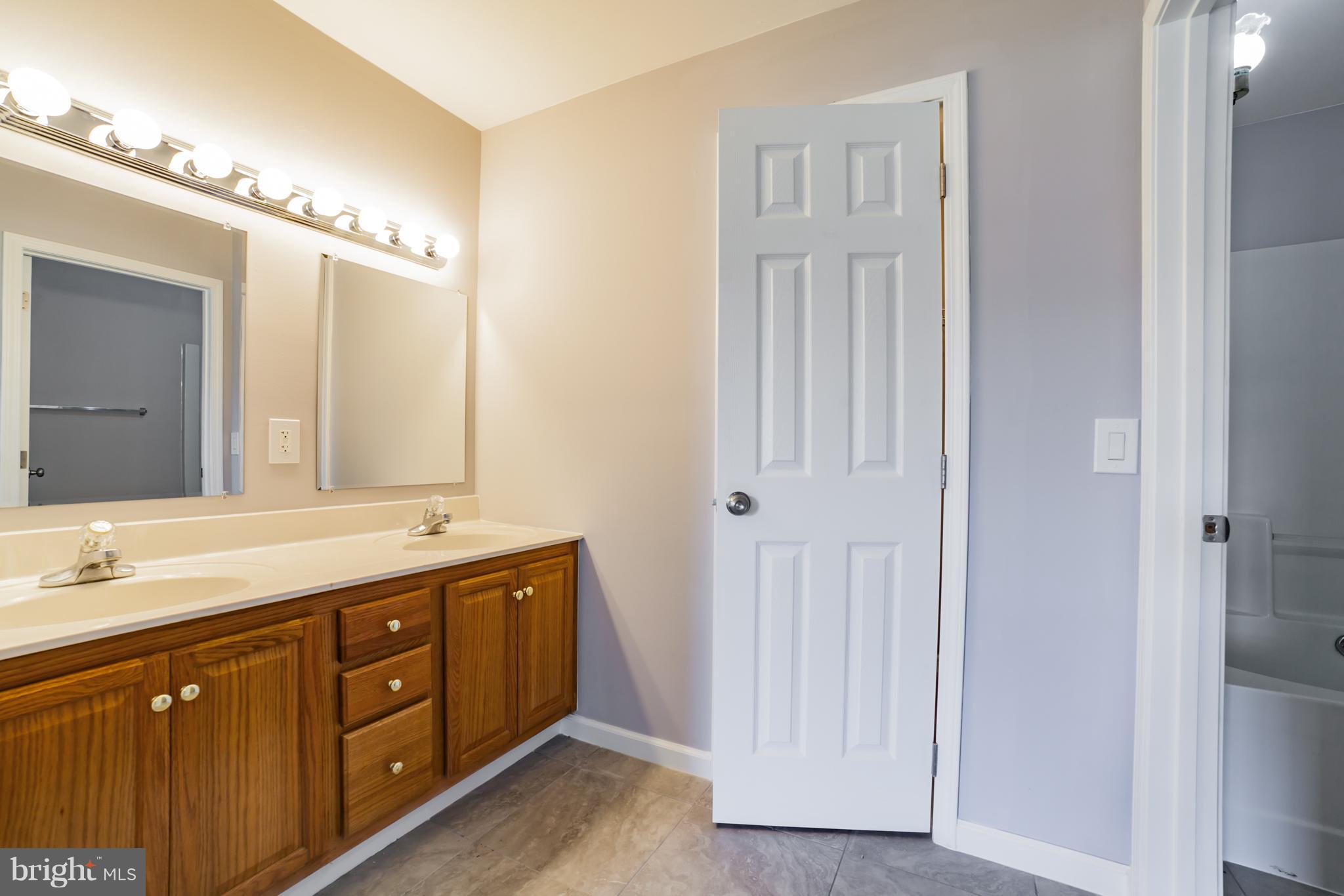 320 W Road Baltimore, MD 21221 - Photo 16 of 30 a spacious bathroom with a double vanity sink and a mirror