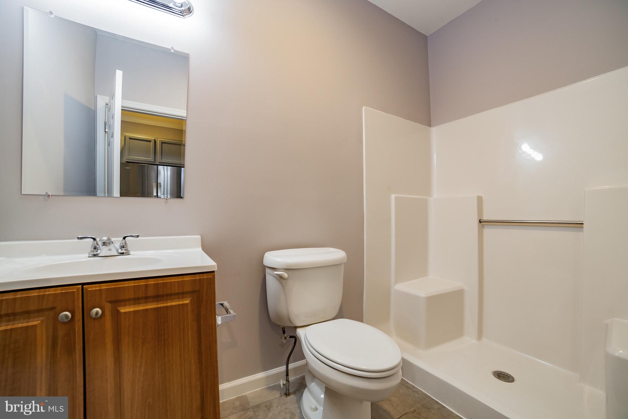 320 W Road Baltimore, MD 21221 - Photo 10 of 30 a bathroom with a granite countertop toilet a sink and a mirror
