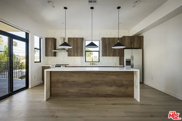 a kitchen with stainless steel appliances granite countertop a stove a sink and a wooden floors