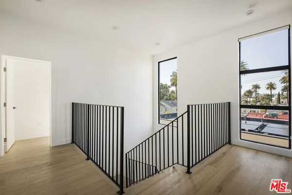 a view of a hallway with wooden floor and windows