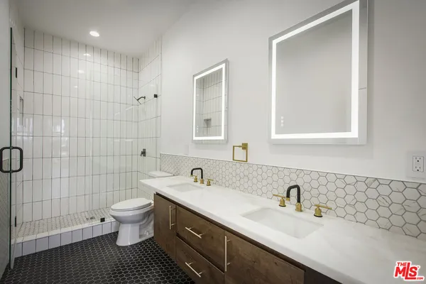 a bathroom with a sink toilet a shower and a mirror
