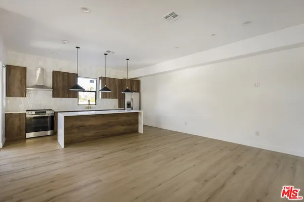 a kitchen with kitchen island a stove and a wooden floor