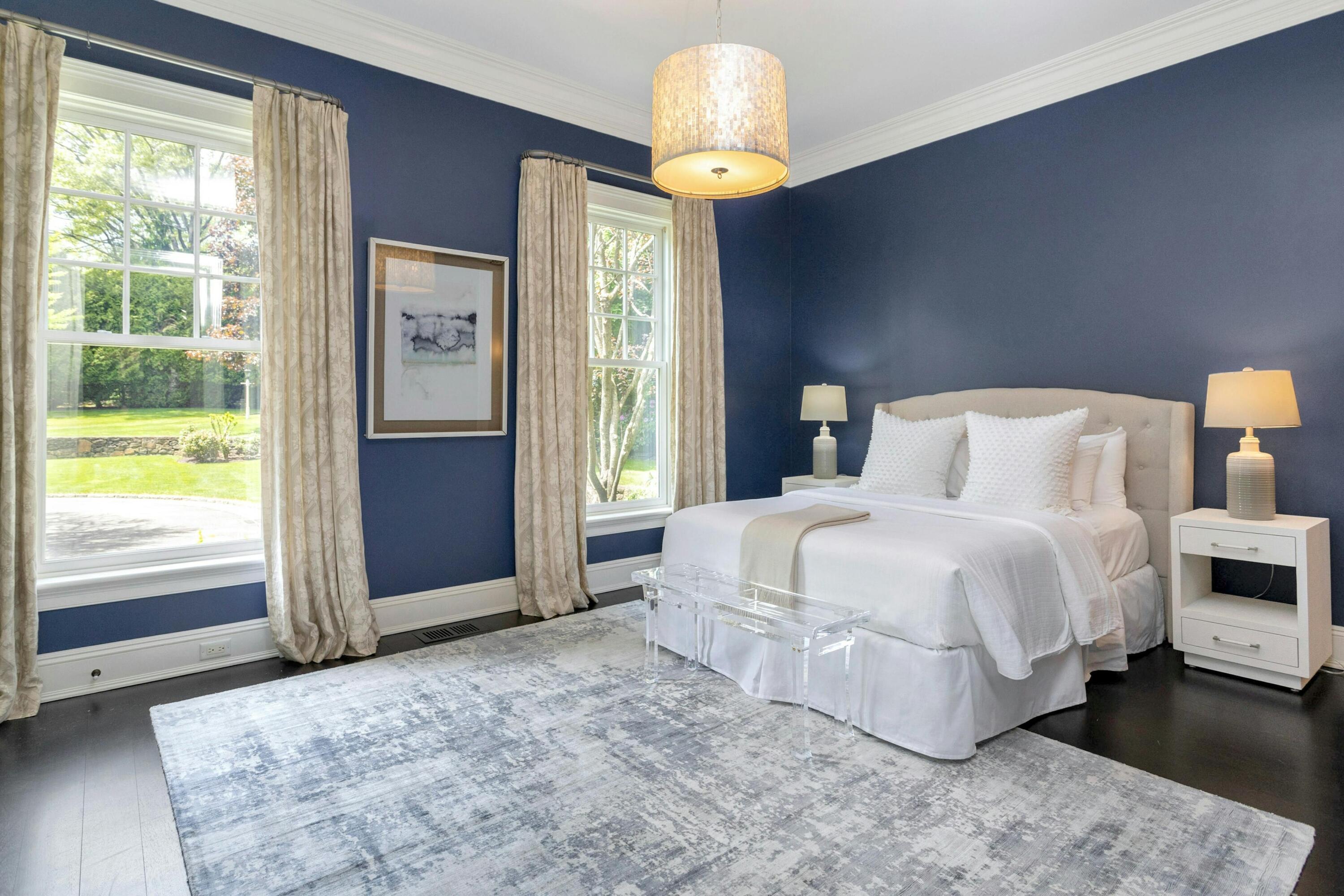 378 Brookside Road Darien, CT 06820 - Photo 21 of 40 a bedroom with a bed and a chandelier