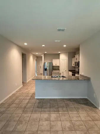 a view of kitchen with kitchen island microwave and cabinets