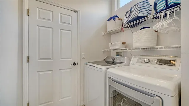 a view of a patio with table and chairs potted plants with floor to ceiling window and potted plants