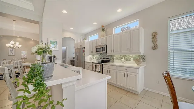 a kitchen with stainless steel appliances white cabinets and a stove top oven
