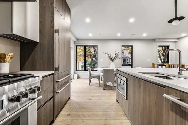 a kitchen with stainless steel appliances granite countertop a stove a sink and a refrigerator