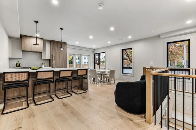 a living room with furniture a large window and wooden floors