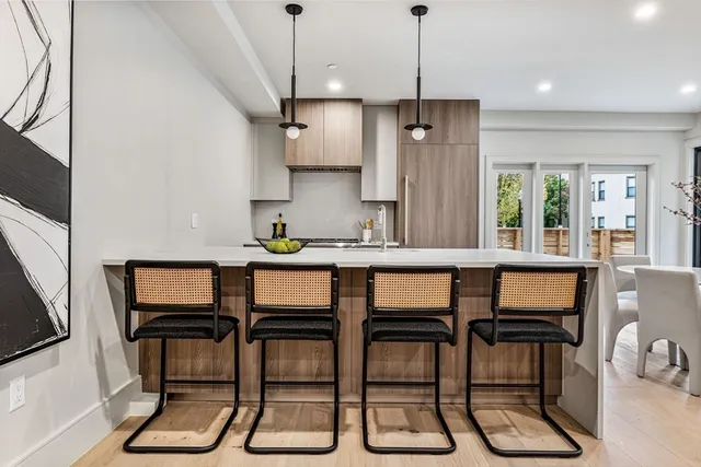a kitchen with granite countertop a dining table chairs and white cabinets