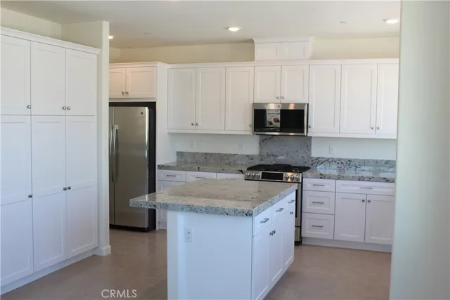 a kitchen with stainless steel appliances granite countertop a stove a refrigerator and a stove