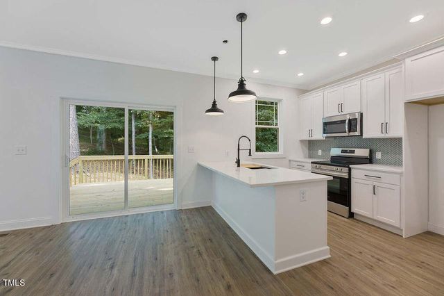 a kitchen with kitchen island granite countertop a stove a sink a microwave and wooden cabinets
