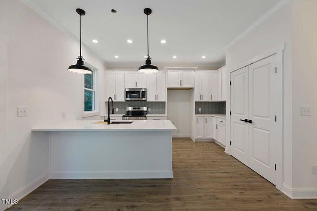 a kitchen with kitchen island white cabinets and stainless steel appliances