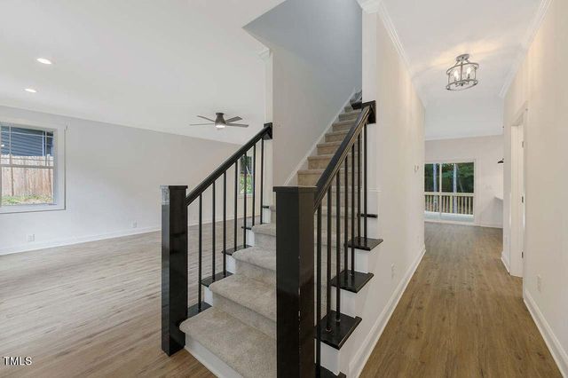 a view of a hallway with wooden floor and staircase