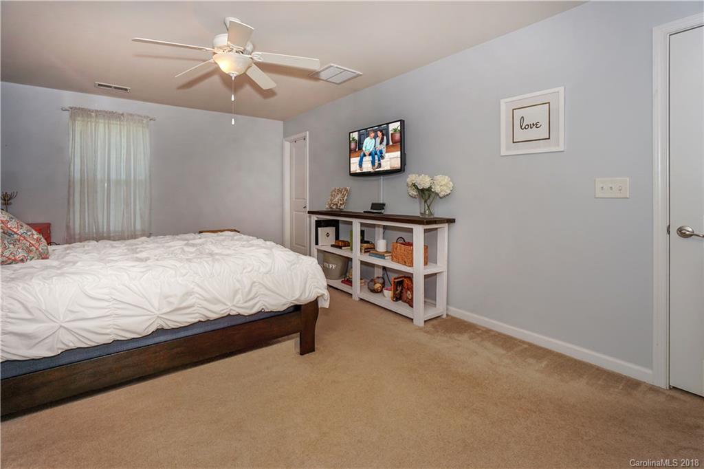 7550 West Berkeley Road, Unit 22 Denver, NC 28037 - Photo 13 of 20 a bedroom with a bed and a chandelier
