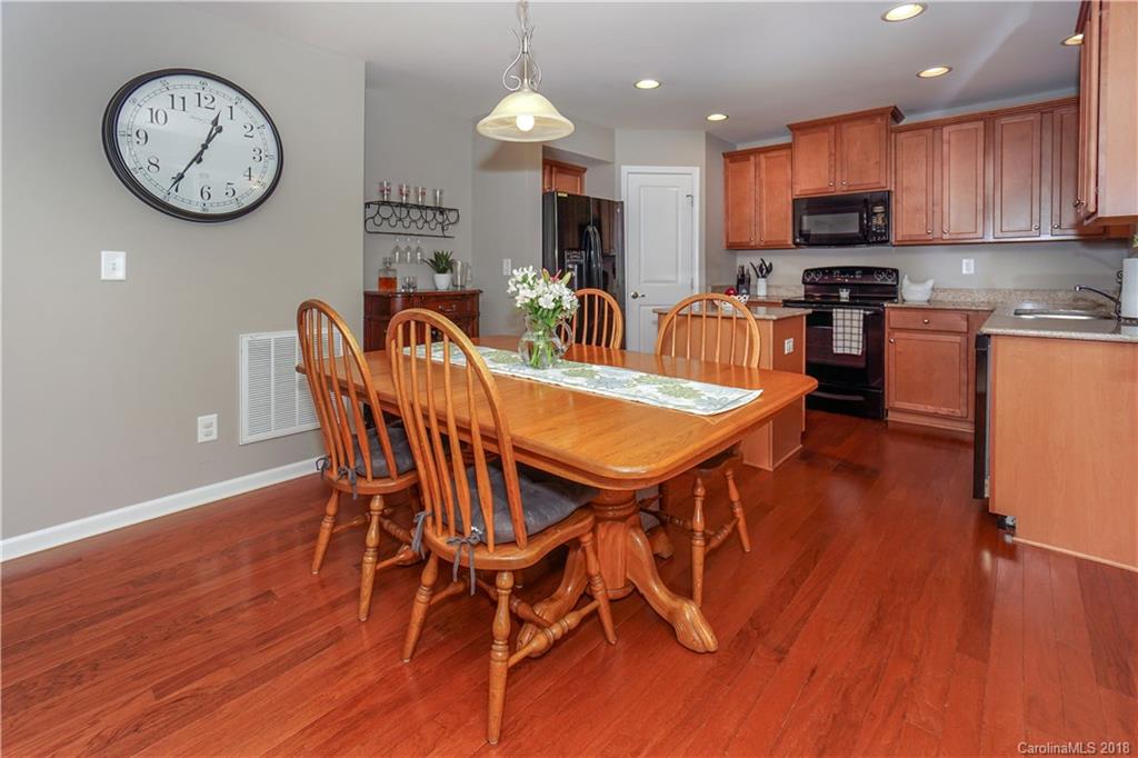 7550 West Berkeley Road, Unit 22 Denver, NC 28037 - Photo 5 of 20 a view of a dining room with furniture wooden floor and a kitchen